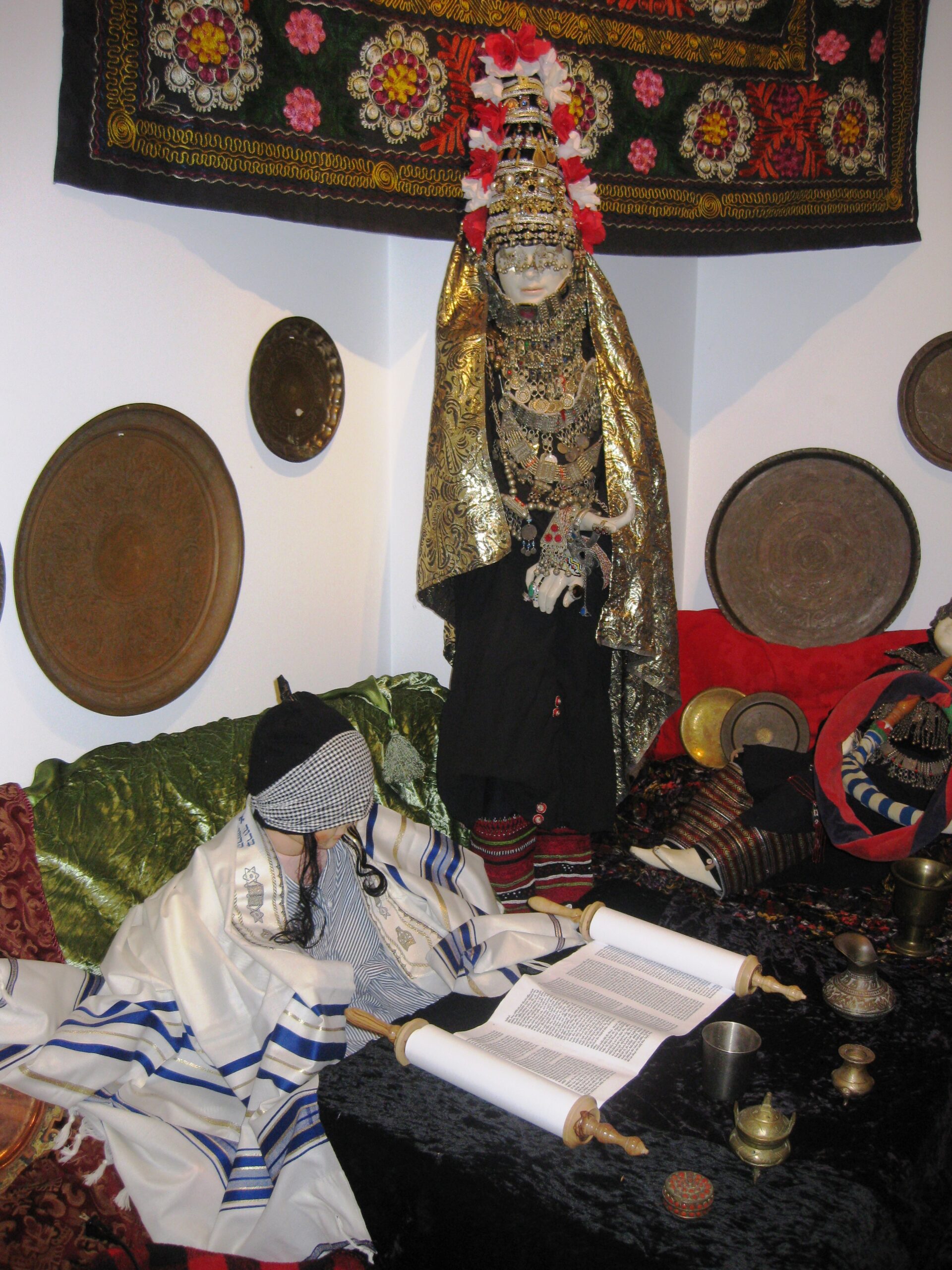 Yemenite heritage room created for Siona Thacker's solo exhibition, featuring traditional Jewish Yemenite clothing, artifacts, Torah scroll, and cultural objects.