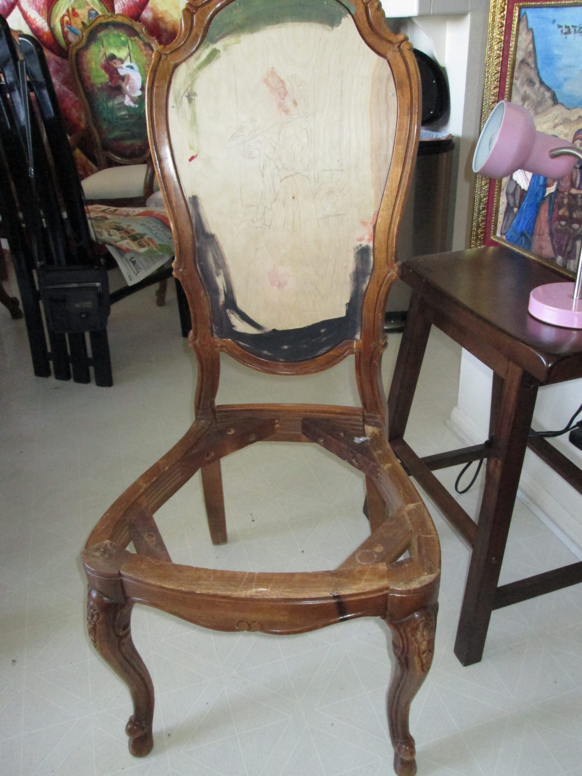 Antique wooden chair during restoration and surface preparation before painting.
