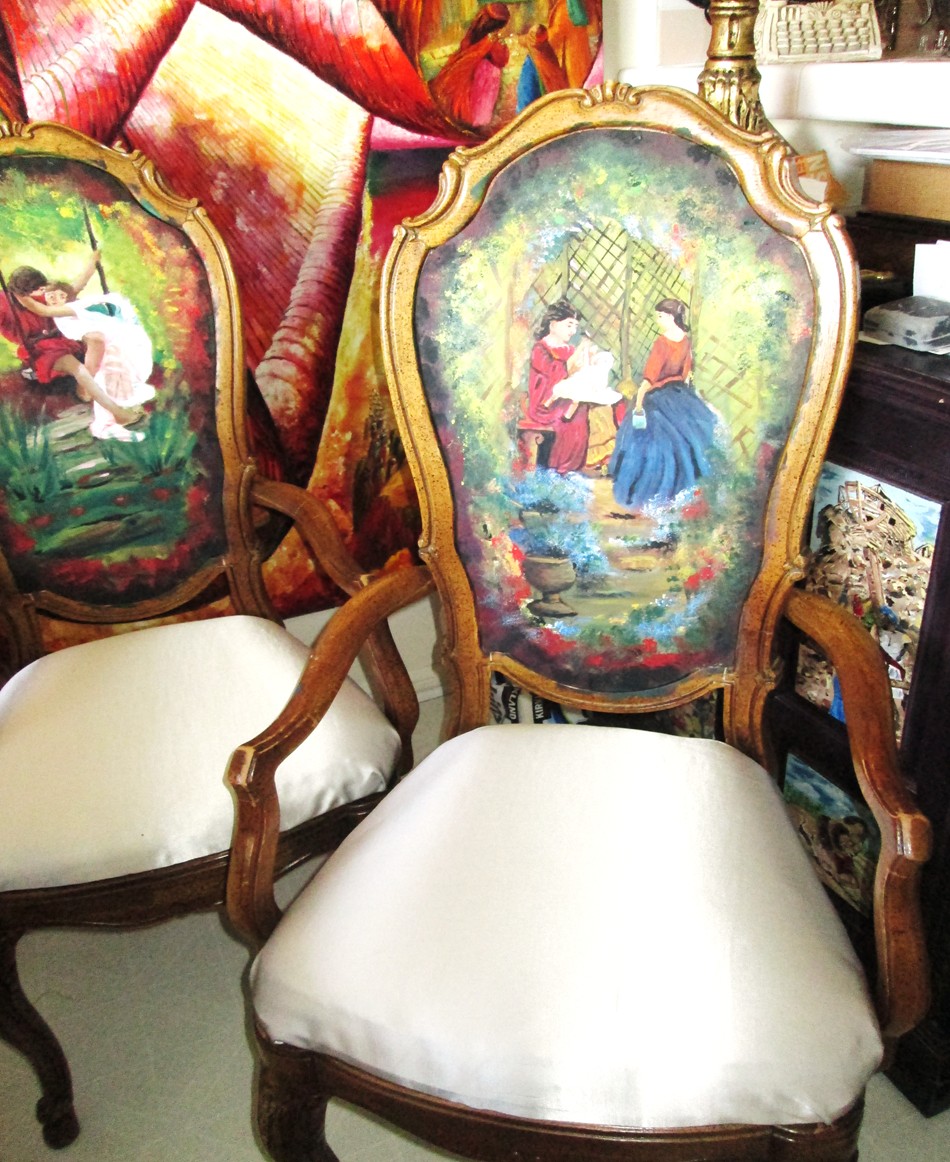 Hand-painted antique dining chairs featuring romantic vintage scenes as part of a restored artistic furniture collection.