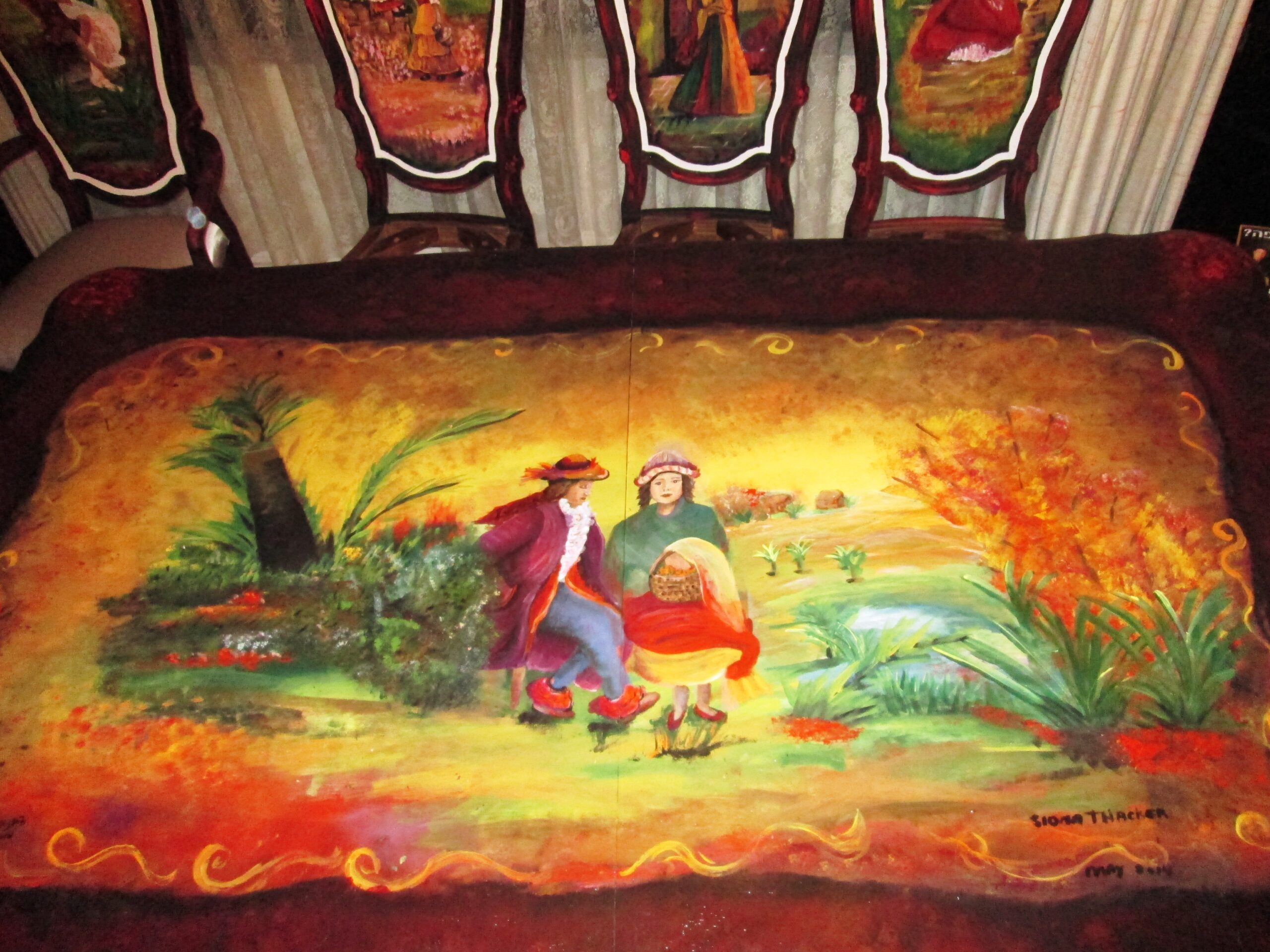 Completed hand-painted antique dining table featuring a romantic countryside scene by Siona Thacker.