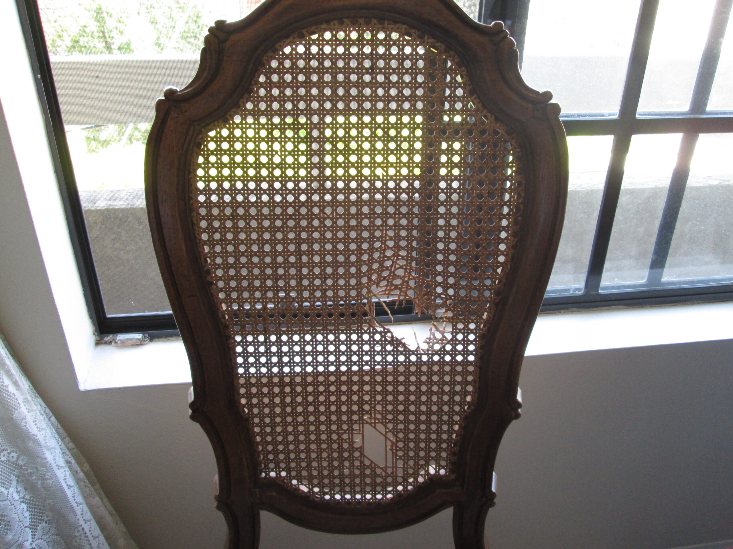 Original antique wooden chair with damaged cane back before restoration and hand-painted artwork.